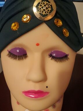 Dark Green Head Covering With Gold Jeweled Accents.